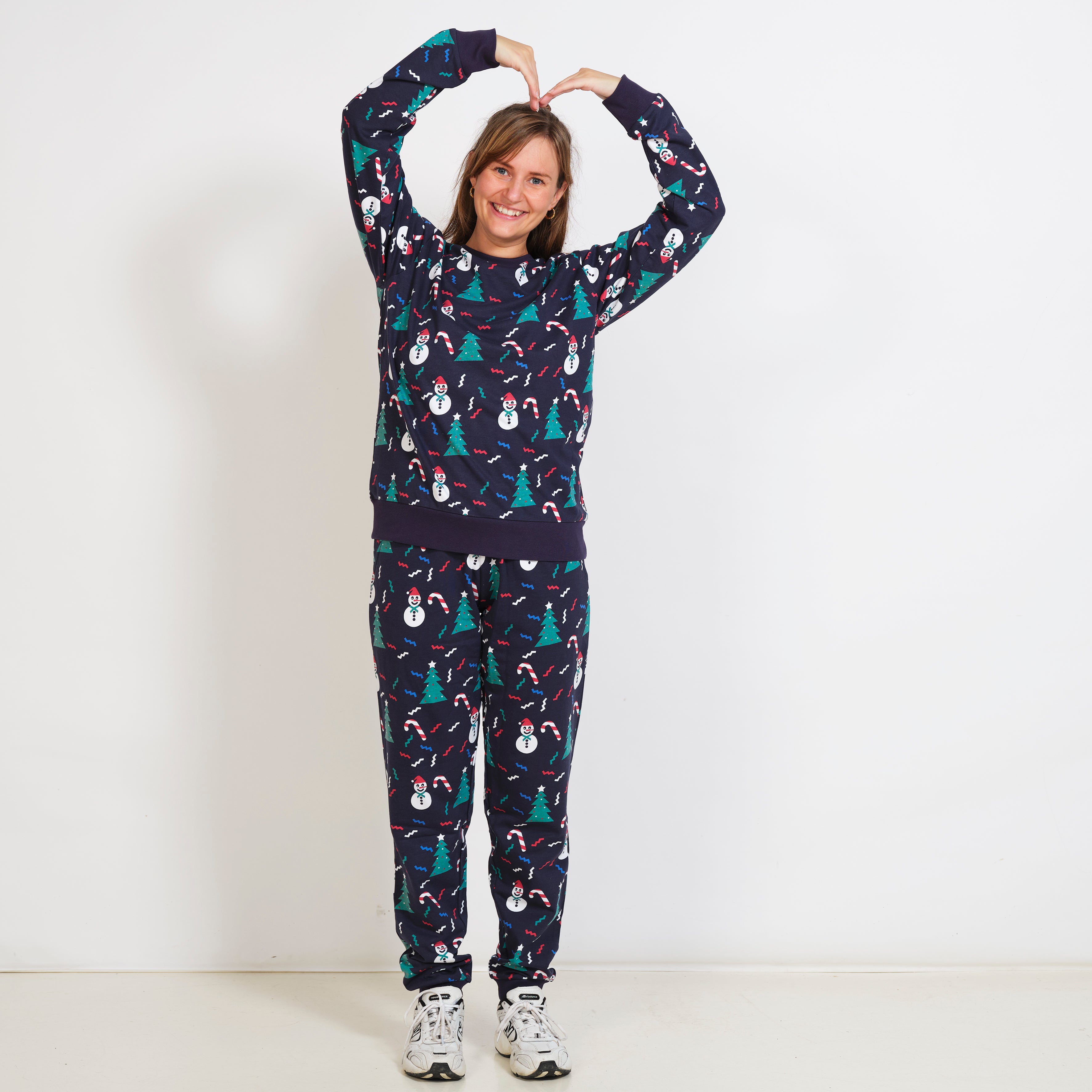En poserende kvinde har et blåt julesweatsuit.